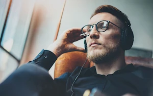Man in glasses listening to music with eyes closed