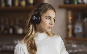 Girl wearing white turtleneck with headphones over the head