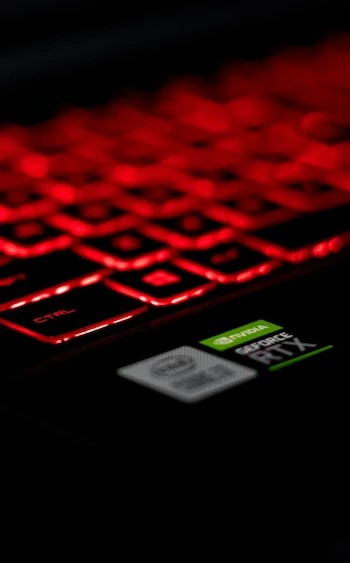 Dark image of gaming laptop with red lit keyboard